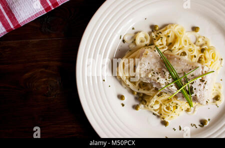 Eine saubere Platte weißen Fisch, Erbsen, Nudeln, Petersilie und Schnittlauch Stockfoto