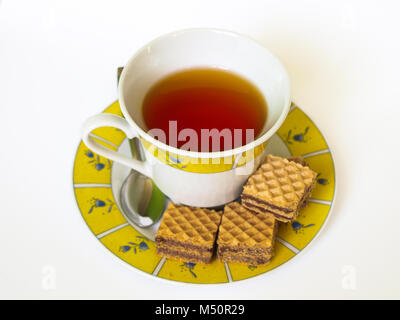 Tasse Kaffee mit Schokolade Wafer, Metall Teelöffel, floral gemusterte kleinen Platte, auf weißem Hintergrund isoliert. Stockfoto