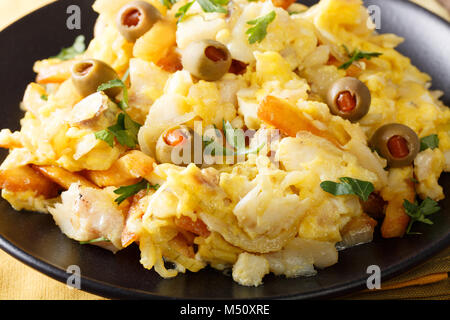 Portugiesische Essen: Gebratene geschreddert Kabeljau mit Pommes frites, Zwiebeln und Eier auf einer Platte close-up. Horizontale Stockfoto