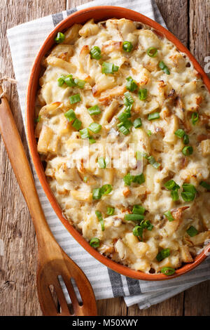 Bacalhau com Natas - gebackener Kabeljau mit Kartoffeln, Zwiebeln und Sahne in einer Auflaufform closeup. Senkrechte Draufsicht von oben Stockfoto