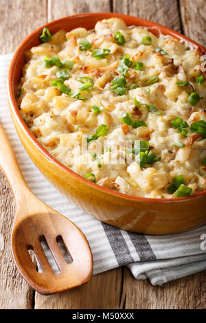 Bacalhau com Natas-Auflauf mit Cod, Kartoffeln, Zwiebeln und Sahne in einer Auflaufform Nahaufnahme auf dem Tisch. Vertikale Stockfoto