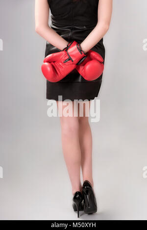 Frau in einem schwarzen Kleid und roten Boxhandschuhe Stockfoto