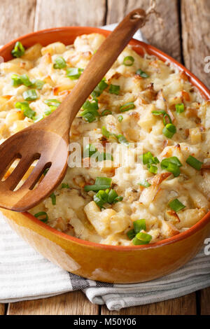 Bacalhau com Natas - gebackener Kabeljau mit Kartoffeln, Zwiebeln und Sahne in einer Auflaufform closeup. Vertikale Stockfoto