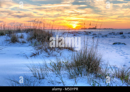 Ein farbenfroher Sonnenuntergang über dem seaoats und Dünen auf Fort Pickens Strand in der Gulf Islands National Seashore, Florida. Stockfoto