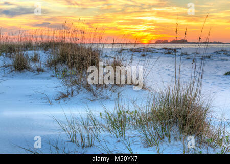 Ein farbenfroher Sonnenuntergang über dem seaoats und Dünen auf Fort Pickens Strand in der Gulf Islands National Seashore, Florida. Stockfoto