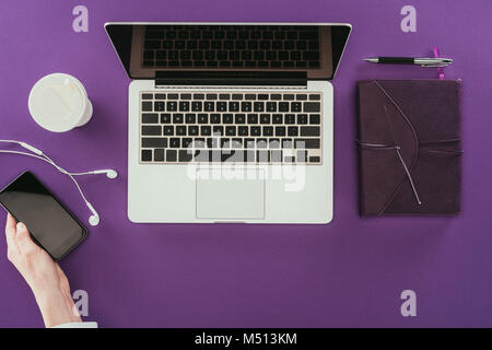 7/8 Schuß moderne Geschäftsfrau mit Smartphone am Arbeitsplatz auf den lila Oberfläche Stockfoto