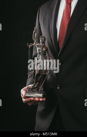 7/8 Schuß von Rechtsanwalt holding Themis Skulptur isoliert auf Schwarz Stockfoto