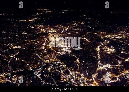 Fliegen bei Nacht über Städte unter Stockfoto