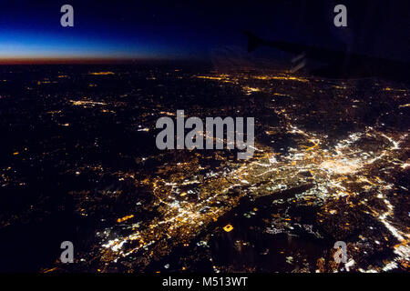 Fliegen bei Nacht über Städte unter Stockfoto