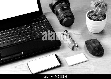 Büro Tisch mit Laptop, Kamera, Smartphone, Brillen, Maus und Visitenkarte. Nützlich als Mock-up Hintergrund Präsentation. Stockfoto