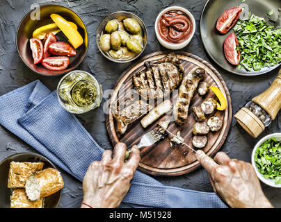 Der Mensch isst ein saftiges Steak grillen. Stockfoto