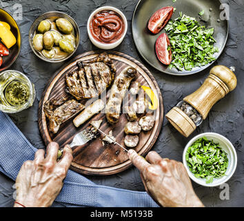 Der Mensch isst ein saftiges Steak grillen. Stockfoto