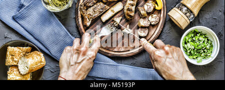 Der Mensch isst ein saftiges Steak grillen. Stockfoto