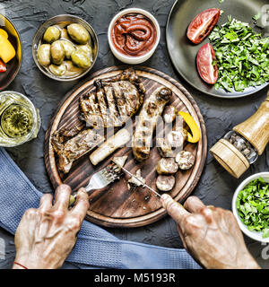 Der Mensch isst ein saftiges Steak grillen. Stockfoto