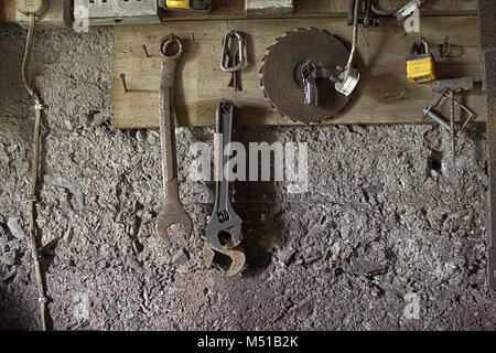 Alte Werkzeuge hängend auf die Nägel in eine Werkstatt. Stockfoto