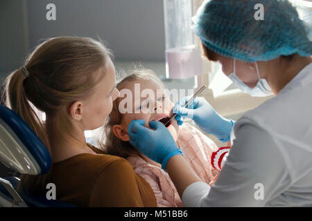 Kleines Mädchen mit Mama in Zahnarzt zimmer-arzt untersucht die Zähne der Mädchen Stockfoto