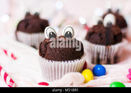 Chocolate Muffins mit essbaren Augen in Papier Halter Stockfoto