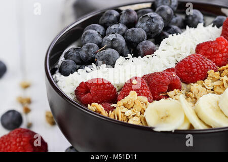 Frühstück Buddha Schüssel mit Chia pudding gefüllt, zuckerfrei Kokos, hausgemachtes Müsli, frische Heidelbeeren, Himbeeren oder Bananen. Extrem flache Dept Stockfoto