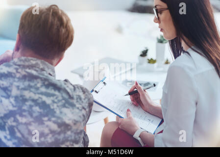 Männliche Soldaten und Therapeuten während der Psychotherapie Sitzung Stockfoto