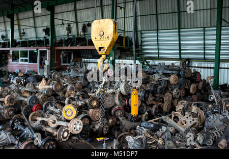 Den Papierkorb Garage Verkauf über altes Auto Radachsen und Teile des Autos Foto mit Innen- und dunkle Beleuchtung. Stockfoto