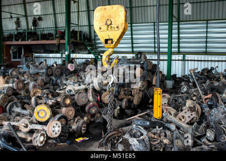 Den Papierkorb Garage Verkauf über altes Auto Radachsen und Teile des Autos Foto mit Innen- und dunkle Beleuchtung. Stockfoto