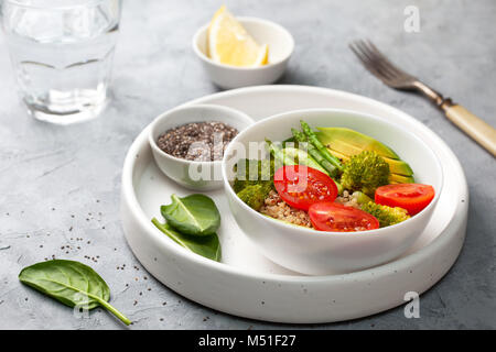 Ernährung gesundes Frühstück. Quinoa und Gemüse: Tomaten, Spargel, Brokkoli, Avocado und Spinat, Chia Samen in einer weißen Schüssel. Stockfoto