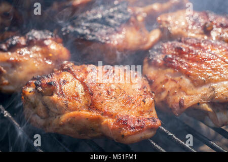 Gegrillte Hähnchenschenkel auf dem brennenden grill Stockfoto