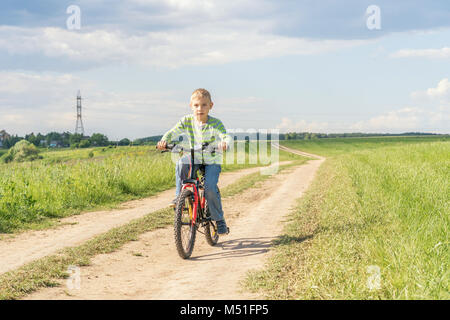 Fröhlicher Junge läuft auf dem Feld Stockfoto