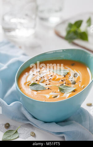 Gebratener Kürbis und Karotten Suppe mit Sahne und Kürbiskerne Stockfoto