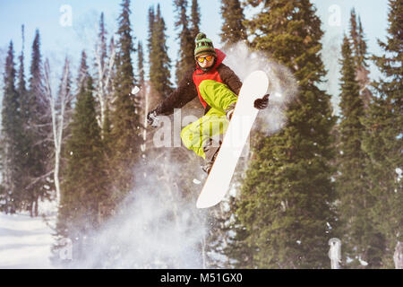 Snowboarder springt auf und offpiste Hang Stockfoto