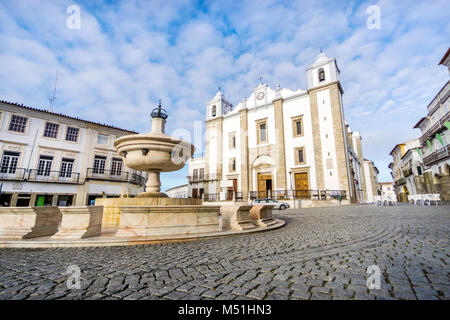 Low-Winkel schräg geschossen von einem Brunnen mit Saint Anton's Kirche im Hintergrund, mit einem close-up Detail aus Granit Pflaster, Platz Praça do Giraldo, Evor Stockfoto