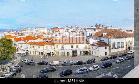 Panoramablick über die Dächer der historischen Altstadt von einem in der Nähe gelegenen Gebäude genommen, mit einem Parkplatz und Cafés in den ersten Plan, Evora, Portugal Stockfoto