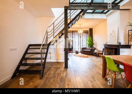 Ein Industrie-Stil stahl Treppe in ein Glas Stock in einem modernen Designer Wohnzimmer. Stockfoto