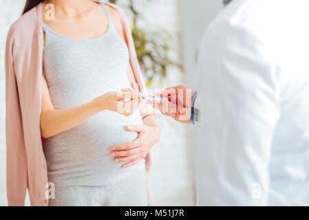 Skaliert auf die werdende Mutter, Arzt Thermometer Stockfoto