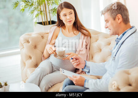 Entspannt schwangere Frau zuhören Während der Termin für den Arzt Stockfoto