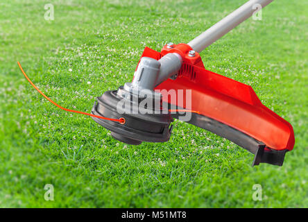 Rasenmäher Big Head trimmer Red Machine auf grünem Gras im Garten Stockfoto