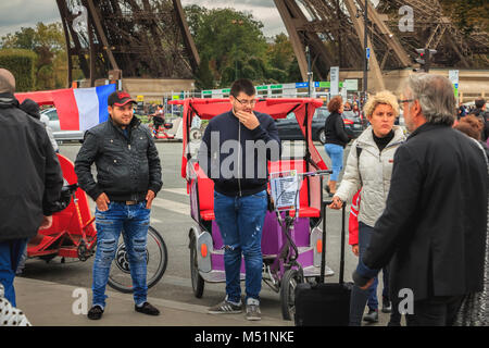 Paris, Frankreich, 08. Oktober, 2017: Rikscha-fahrer für Kunden, die neben dem Eiffelturm auf einem Herbst Tag warten Stockfoto