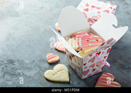 Vanillezucker schneiden Sie Cookies mit rosa Glasur und Streuseln für Valentines Tag in einer Box behandeln Stockfoto