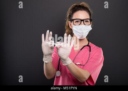 Portrait von attraktiven Dame Arzt brechen wie keine Zigarette rauchen Konzept auf schwarzen Hintergrund mit copypsace Werbefläche Stockfoto