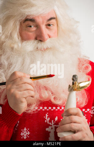 Santa Claus Spielzeug. Malerei und Färbung Weihnachten Dekoration von Angel Statue Stockfoto