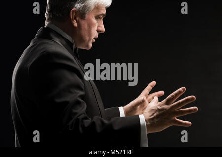 Closeup Portrait von männlichen Orchester Dirigent leitet mit seinen Händen in Concert. Business führenden Konzept Stockfoto
