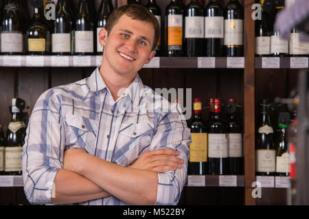 Portrait von zuversichtlich männliche Hände mit einer Auswahl an Weinen im Hintergrund gefaltet Stockfoto