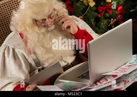 Santa Claus Arbeiten am Computer das Lesen von E-Mails und Briefe von Kindern aus aller Welt Stockfoto