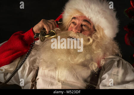 Portrait von emotionalen Santa Claus die Telefonnummer zu Hause Stockfoto
