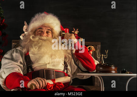 Portrait von emotionalen Santa Claus die Telefonnummer zu Hause Stockfoto