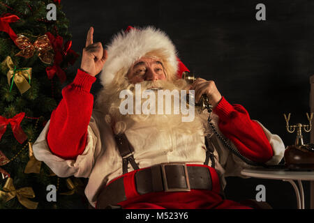 Portrait von emotionalen Santa Claus die Telefonnummer zu Hause Stockfoto