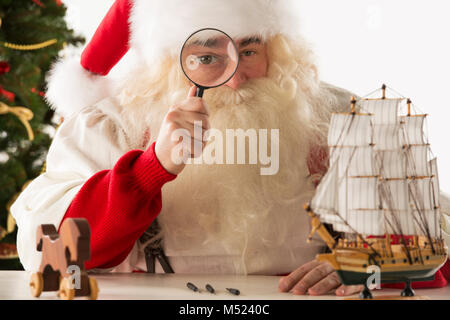 Santa Claus Spielzeug. Mit Blick auf die Kamera durch die Lupe vergrößern Stockfoto