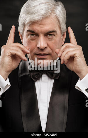 Portrait von Stattlichen reifen Business Leader auf schwarzem Hintergrund Stockfoto