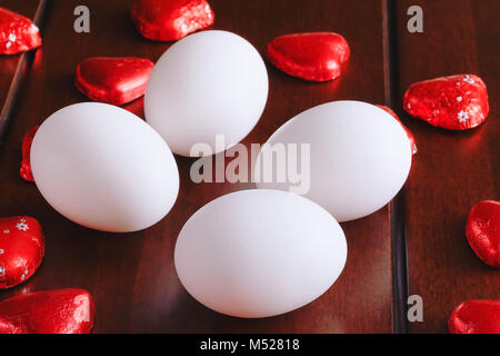 Beste weiße Eier Bild mit Rot Dekoration, auf Holz Hintergrund. Konzept der perfekte Eier Formen, Ostern, Individualität, Eleganz und Reinheit. Stockfoto