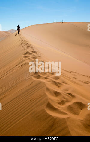 Silhouetten von drei Personen, Wüste Namib, Namibia Stockfoto